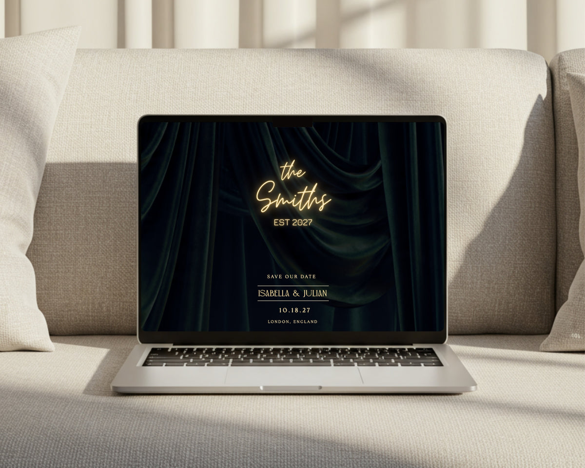 Art deco save the date wedding website open on a laptop on a sofa, showing the neon marquee with the couple's names and wedding date.