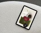 Olive green save the date website template on a tablet, showing the opened invitation with calla lilies, a scalloped portrait frame and a burgundy lace heart.