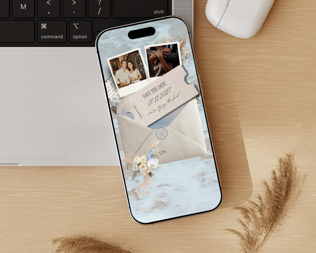 Digital save the date website on a phone, styled on a wooden desk beside a keyboard.