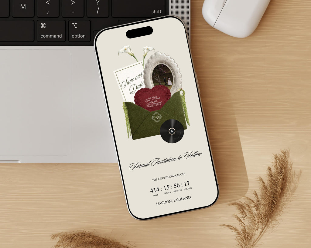 Olive green classical save the date website displayed on a phone, styled on a wooden desk.
